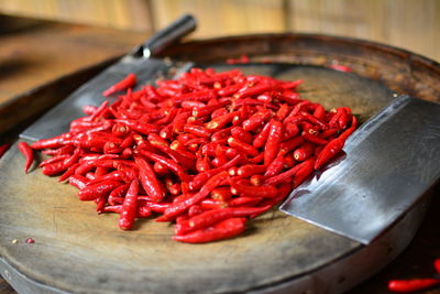 Close-up of red chili peppers with kitchen knives