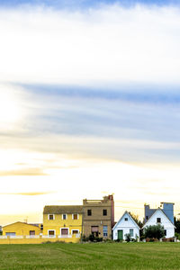 Houses on field against sky