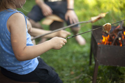 Bread on stick. cooking at picnic. white piece of bread is strung on sticks made of wood. 