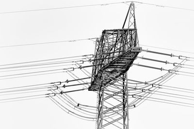 Low angle view of electricity pylon against clear sky