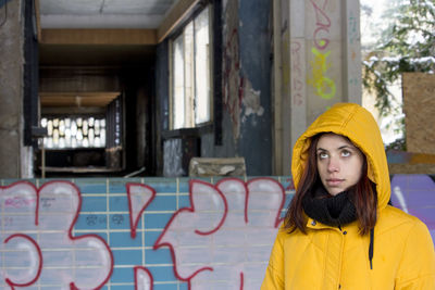 Portrait of teenage girl at the street in yellow hood