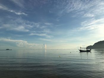 Scenic view of sea against sky and a small fishing boat.