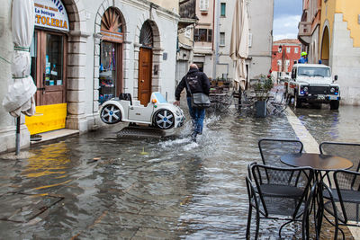 View of wet street in city during rainy season