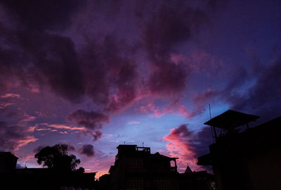 Low angle view of buildings against sky at sunset