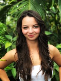 Portrait of smiling young woman against plants