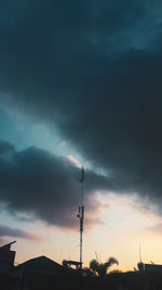 Low angle view of silhouette communications tower against sky during sunset