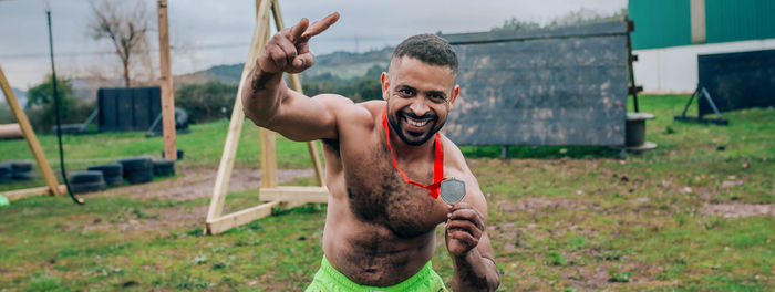 Portrait of man holding camera on field