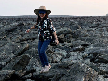 Portrait of smiling woman standing on rock