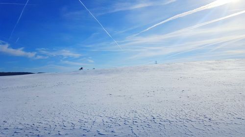 Scenic view of vapor trails against blue sky