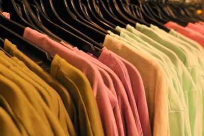 Multi colored clothes hanging on display at store