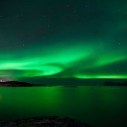 Scenic view of lake against sky at night