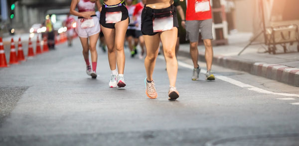 Low section of woman walking on road