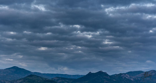 Scenic view of mountains against cloudy sky