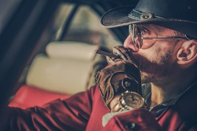 Man smoking cigarette while sitting in car