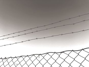 Low angle view of barbed wire against clear sky