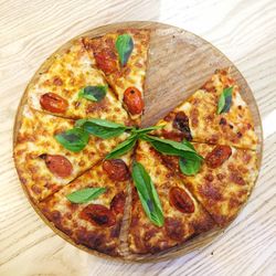 High angle view of pizza on cutting board over table