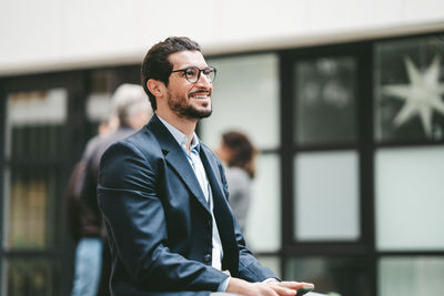 Portrait of young man standing in office