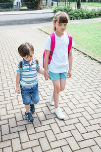 Sad sister and brother go to school. children are sad about the end of the holidays 