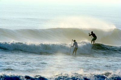 People surfing in sea