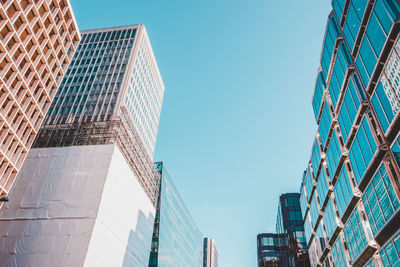 Low angle view of skyscrapers against clear blue sky