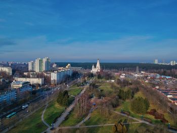 High angle view of buildings in city against blue sky