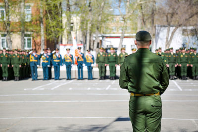 Rear view of people standing on street in city