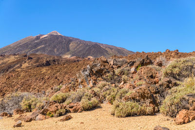 Scenic view of mountains against clear blue sky