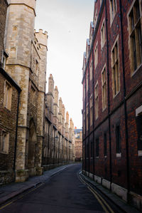 Empty road amidst buildings against clear sky