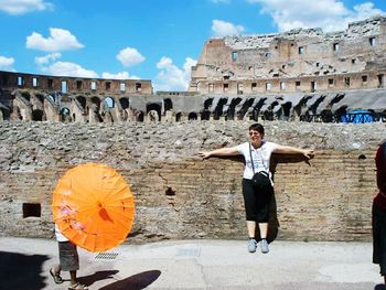 Full length of man with arms outstretched against sky