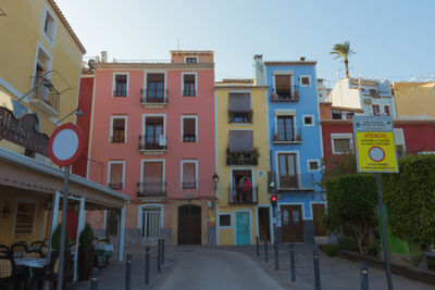 Road by buildings against sky in city