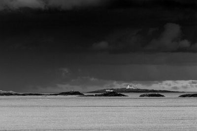 Lighthouse on an island under heavy clouds