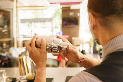 Bartender preparing drink in bottle at counter