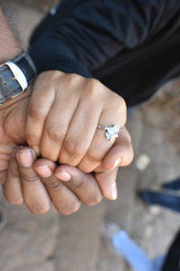 Midsection of couple holding hands