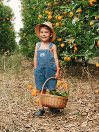 Toddler boy smoking in a orange orchard.sunmertime between oranges trees