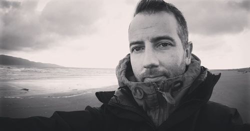 Portrait of man by sea against sky