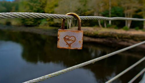 Close-up of padlock on cable against river