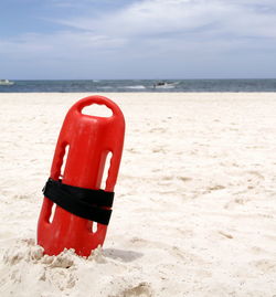 Red umbrella on beach against sky