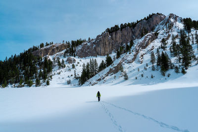 Person skiing on snowcapped mountain against sky