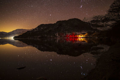 Scenic view of lake against sky at night