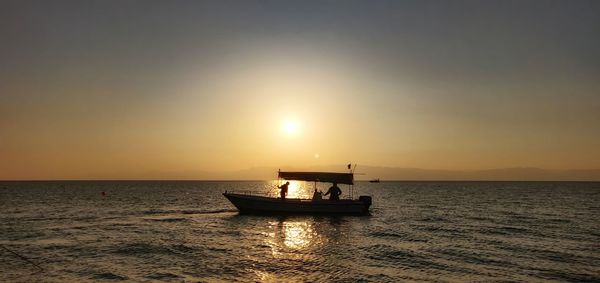 Sailboat in sea against sky during sunset