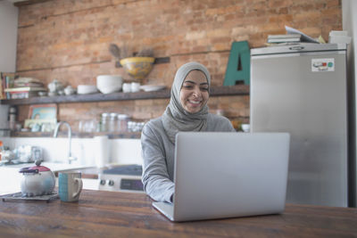 Muslim businesswoman working from home on her laptop