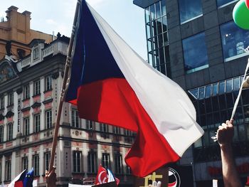 Low angle view of flag against buildings in city