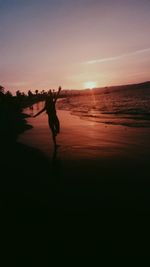 Silhouette of man walking on beach