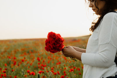 Woman holding bouquet of poppies