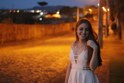 Portrait of happy young woman at night