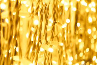 Garland with warm yellow light close-up in defocus. festive bright background