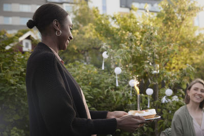 Smiling woman holding birthday cake