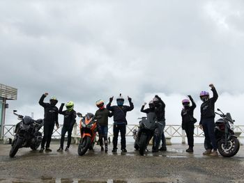 Group of people against cloudy sky