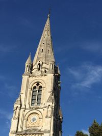 Low angle view of bell tower against blue sky