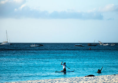 Man surfing in sea against sky